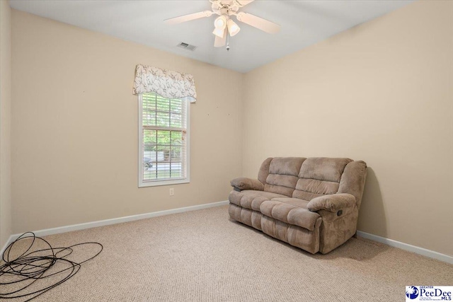 living area featuring visible vents, a ceiling fan, carpet, and baseboards
