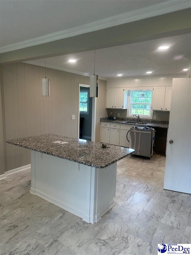 kitchen featuring crown molding, stainless steel dishwasher, white cabinets, and a kitchen island