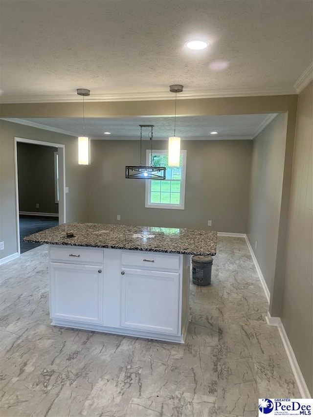 kitchen featuring white cabinetry, dark stone counters, a kitchen island, and pendant lighting