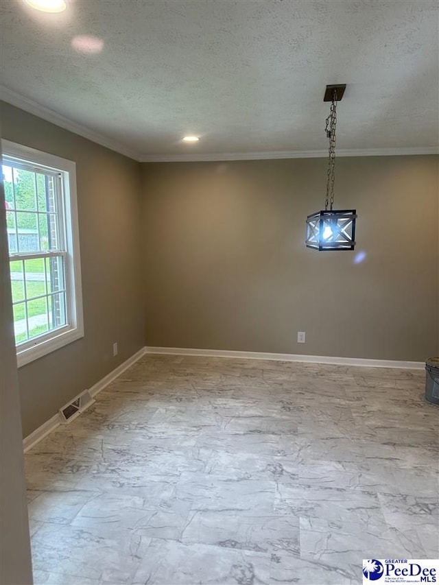 unfurnished dining area with ornamental molding and a textured ceiling