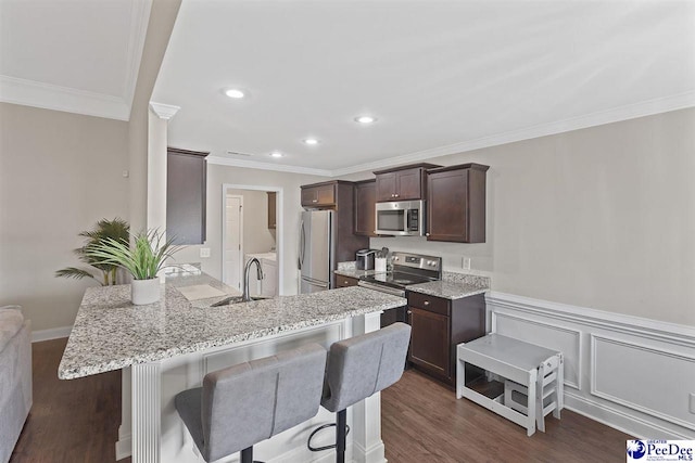 3209 Haven Straits, Florence, SC 29505 - kitchen featuring appliances with stainless steel finishes, dark brown cabinetry, a peninsula, ornamental molding, and dark wood-style flooring