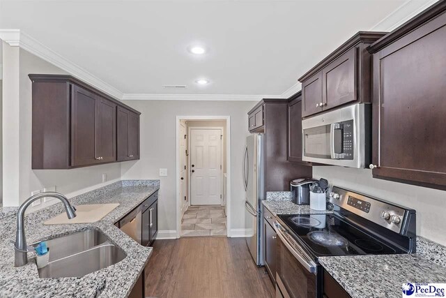 3209 Haven Straits, Florence, SC 29505 - kitchen featuring appliances with stainless steel finishes, a sink, dark brown cabinets, baseboards, and light stone counters