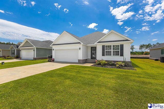 3209 Haven Straits, Florence, SC 29505 - view of front facade with a garage, concrete driveway, a front lawn, and cooling unit