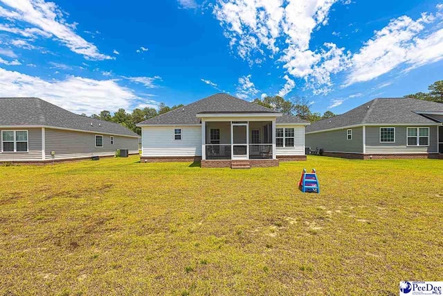 3209 Haven Straits, Florence, SC 29505 - back of property featuring a sunroom, a lawn, roof with shingles, and central air condition unit