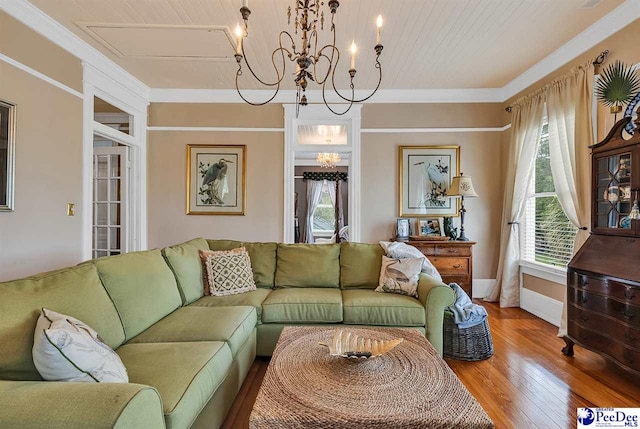 living room featuring wood-type flooring, ornamental molding, a notable chandelier, and wood ceiling