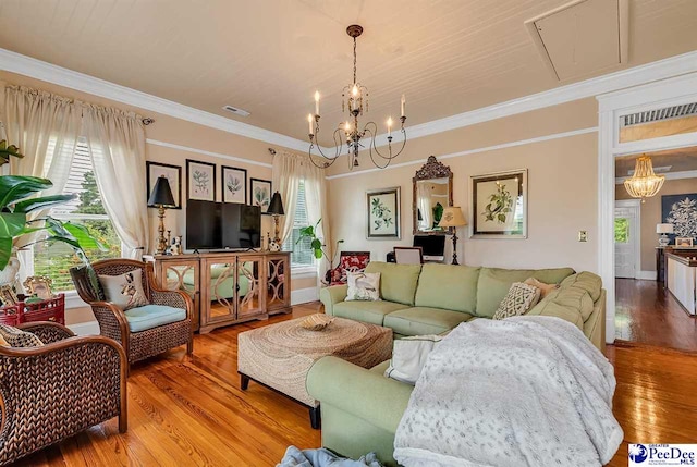 living room with crown molding, hardwood / wood-style flooring, and a chandelier