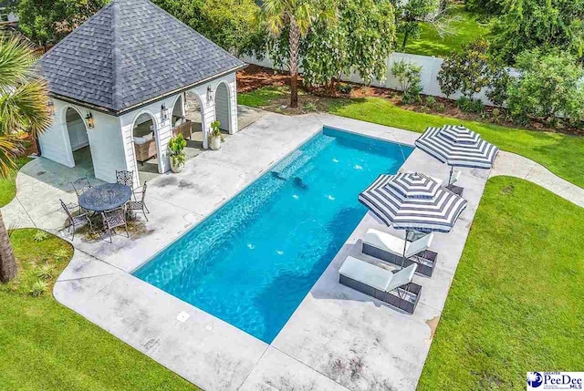 view of pool with a yard, an outdoor structure, and a patio