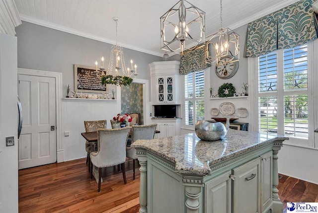 kitchen with wood-type flooring, a center island, a notable chandelier, and crown molding