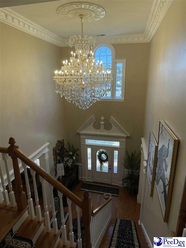 foyer entrance featuring crown molding, dark hardwood / wood-style floors, and a notable chandelier