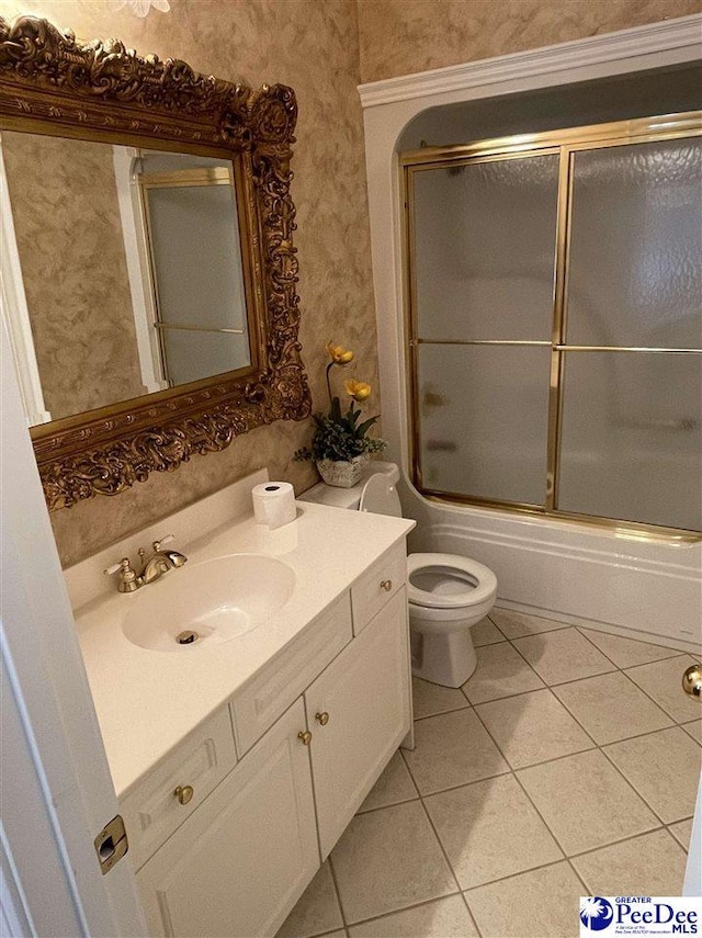 full bathroom featuring enclosed tub / shower combo, vanity, tile patterned floors, and toilet