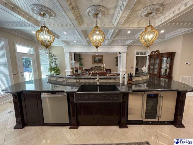 kitchen featuring decorative columns, dishwasher, and an inviting chandelier