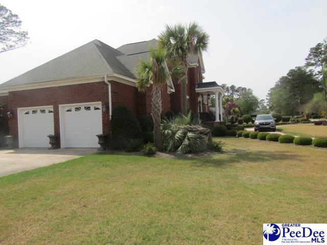 view of side of property featuring a garage and a lawn