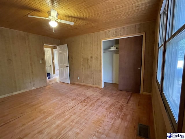 1009 Trailwood Dr, Hartsville, SC 29550 - unfurnished bedroom with light wood-type flooring, wood ceiling, wooden walls, a closet, and ceiling fan