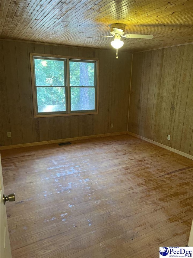 1009 Trailwood Dr, Hartsville, SC 29550 - unfurnished room with wooden ceiling, plenty of natural light, wood-type flooring, a ceiling fan, and wood walls