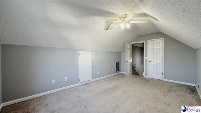 bonus room with lofted ceiling, light carpet, a textured ceiling, and ceiling fan