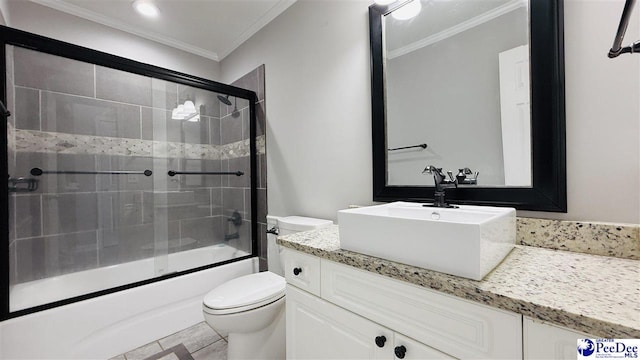 full bathroom featuring ornamental molding, combined bath / shower with glass door, vanity, and toilet