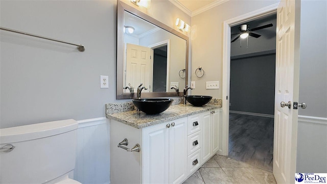 bathroom with ceiling fan, tile patterned flooring, vanity, ornamental molding, and toilet