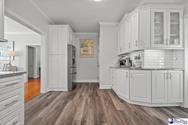 100 Mckellar St, Bennettsville, SC 29512 - kitchen with stainless steel refrigerator, white cabinetry, dark wood-style floors, glass insert cabinets, and light stone counters