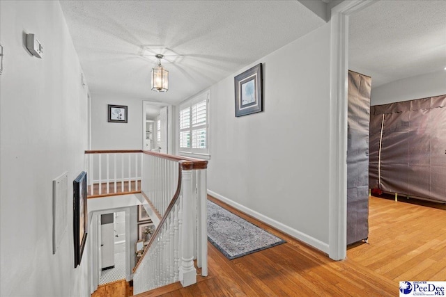 100 Mckellar St, Bennettsville, SC 29512 - hall featuring an upstairs landing, wood finished floors, a textured ceiling, and baseboards
