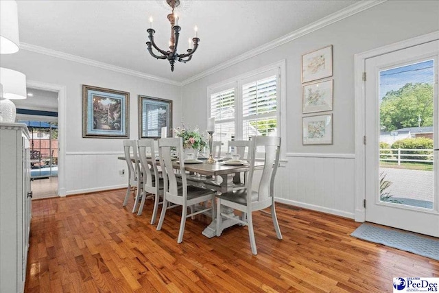 100 Mckellar St, Bennettsville, SC 29512 - dining room featuring a chandelier, light wood-style flooring, healthy amount of natural light, a wainscoted wall, and crown molding