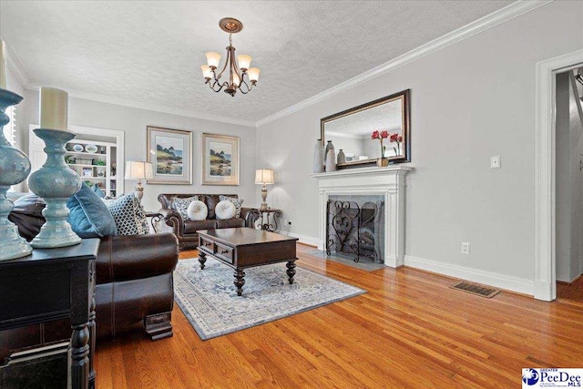 100 Mckellar St, Bennettsville, SC 29512 - living room featuring a chandelier, wood finished floors, a textured ceiling, a fireplace with flush hearth, and baseboards