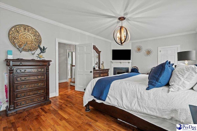 100 Mckellar St, Bennettsville, SC 29512 - bedroom with ornamental molding, wood finished floors, baseboards, and a fireplace