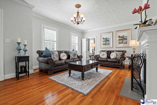 100 Mckellar St, Bennettsville, SC 29512 - living room featuring a chandelier, a textured ceiling, light wood-style flooring, crown molding, and baseboards