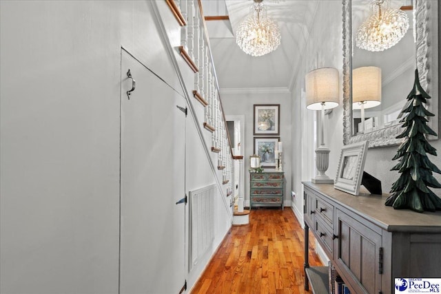 100 Mckellar St, Bennettsville, SC 29512 - hall featuring ornamental molding, a chandelier, stairway, light wood-style floors, and baseboards