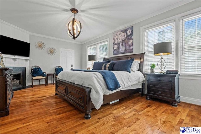100 Mckellar St, Bennettsville, SC 29512 - bedroom with multiple windows, light wood-type flooring, crown molding, a chandelier, and a fireplace