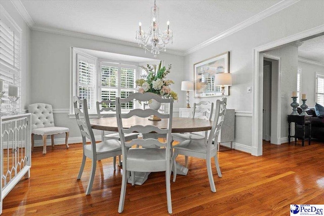 100 Mckellar St, Bennettsville, SC 29512 - dining area with healthy amount of natural light, a chandelier, crown molding, wood finished floors, and a textured ceiling