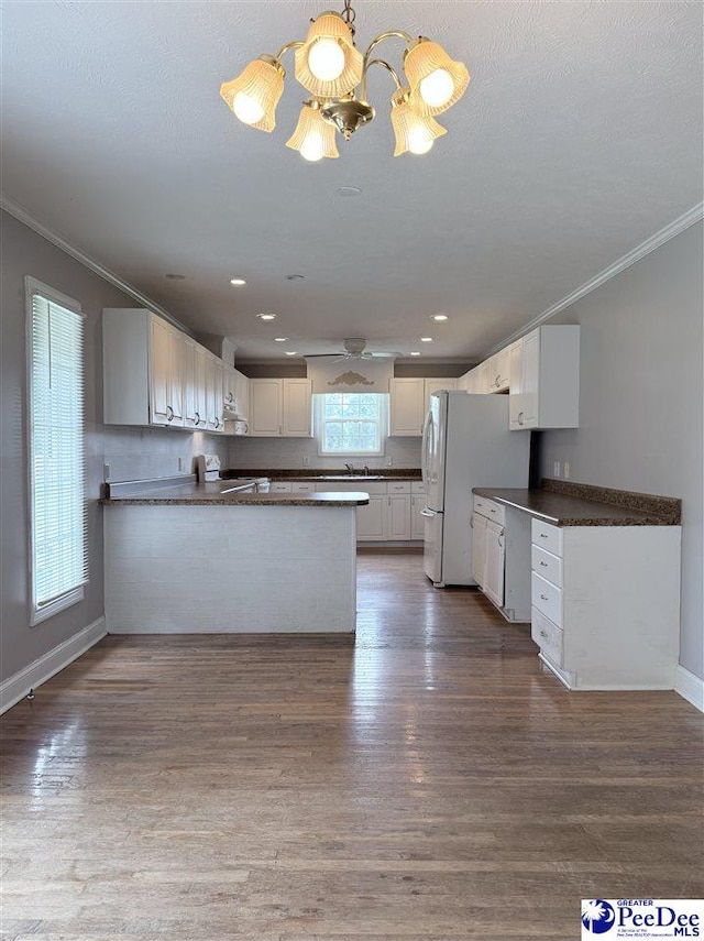 148 High Hill Rd, Lake View, SC 29563 - kitchen with ornamental molding, dark countertops, a chandelier, freestanding refrigerator, and a peninsula