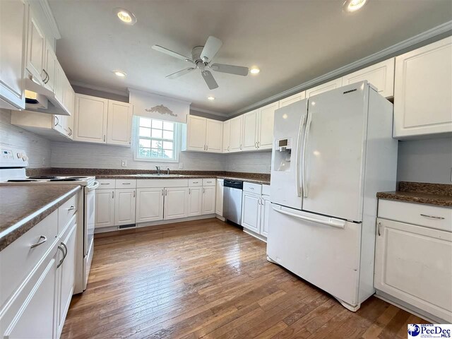 148 High Hill Rd, Lake View, SC 29563 - kitchen with white appliances, dark countertops, under cabinet range hood, decorative backsplash, and crown molding