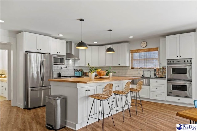 kitchen featuring wood counters, appliances with stainless steel finishes, and white cabinets