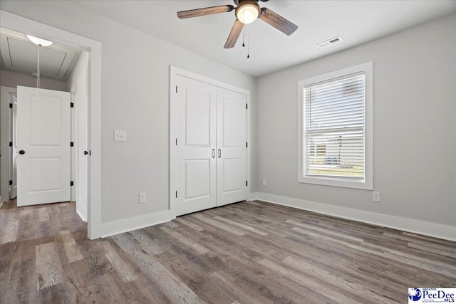 unfurnished bedroom featuring hardwood / wood-style flooring, a closet, and ceiling fan