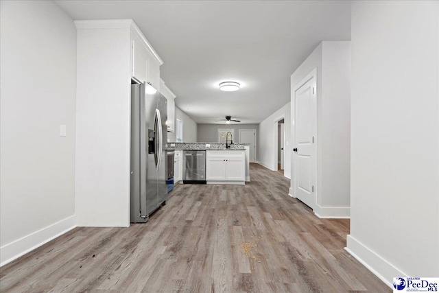 kitchen featuring white cabinetry, appliances with stainless steel finishes, sink, and light wood-type flooring