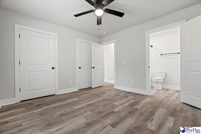 unfurnished bedroom featuring ceiling fan, connected bathroom, and light wood-type flooring