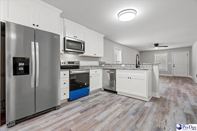 kitchen featuring appliances with stainless steel finishes, white cabinets, and light hardwood / wood-style floors