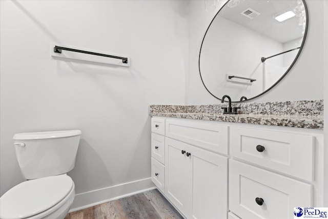 bathroom featuring vanity, hardwood / wood-style floors, and toilet