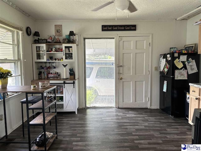 dining space featuring dark wood-type flooring, ceiling fan, crown molding, and a textured ceiling