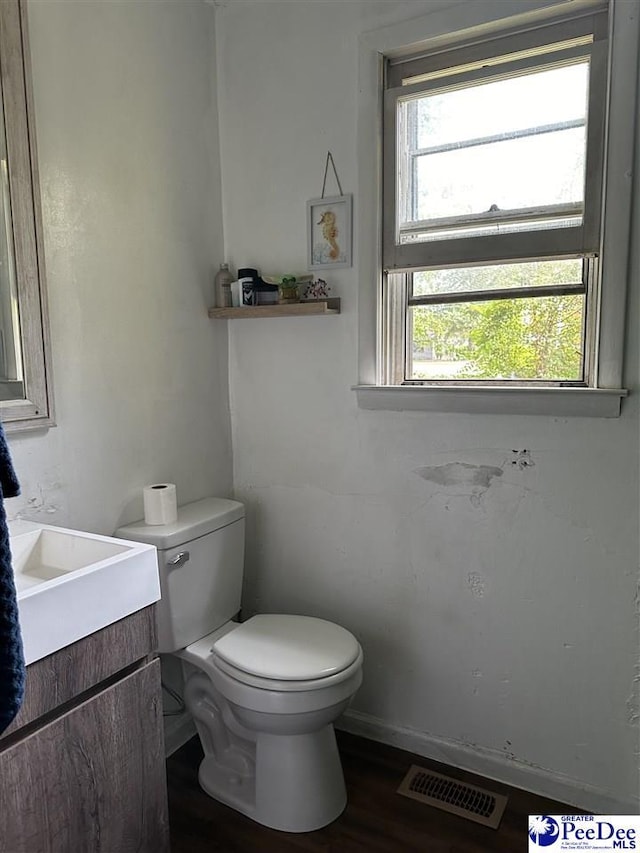 bathroom with hardwood / wood-style flooring, vanity, and toilet