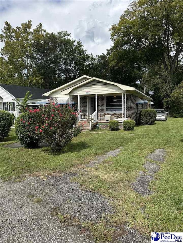 bungalow-style house featuring a porch and a front lawn