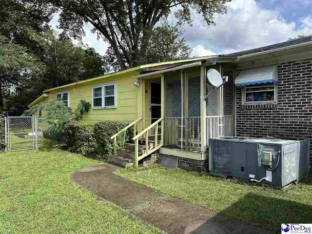 view of front facade with a front yard and central air condition unit