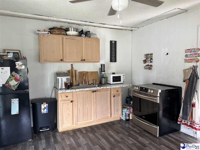 kitchen featuring sink, black refrigerator, dark hardwood / wood-style floors, a textured ceiling, and stainless steel electric range oven