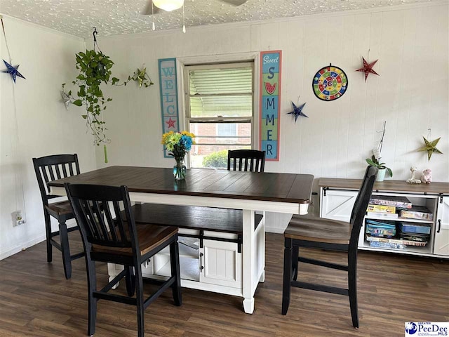 dining space with dark hardwood / wood-style flooring, ornamental molding, and a textured ceiling