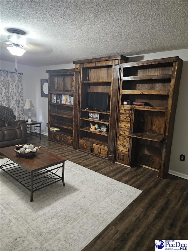 living room with a textured ceiling and dark hardwood / wood-style flooring