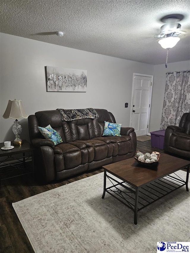 living room with dark hardwood / wood-style flooring and a textured ceiling