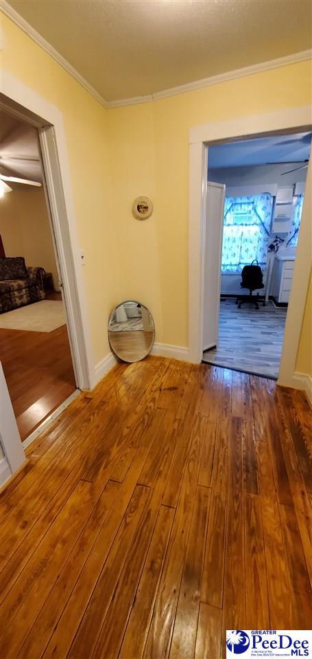 107 Patterson St, Bennettsville, SC 29512 - corridor featuring crown molding, hardwood / wood-style floors, and baseboards