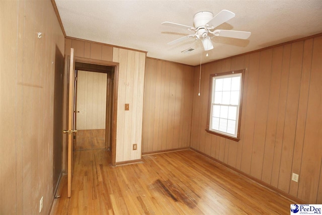 unfurnished room featuring crown molding, ceiling fan, and light wood-type flooring