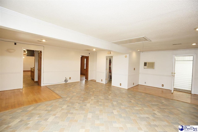 empty room with a wall mounted AC and a textured ceiling