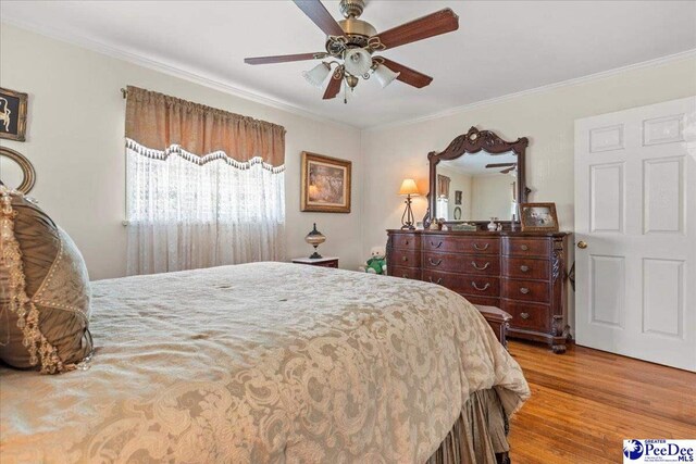 2338 W Mccown Dr, Florence, SC 29501 - bedroom with wood finished floors, crown molding, and a ceiling fan